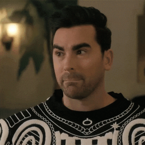 A GIF of David from Schitt's Creek rolling his eyes back while saying, 'K.'